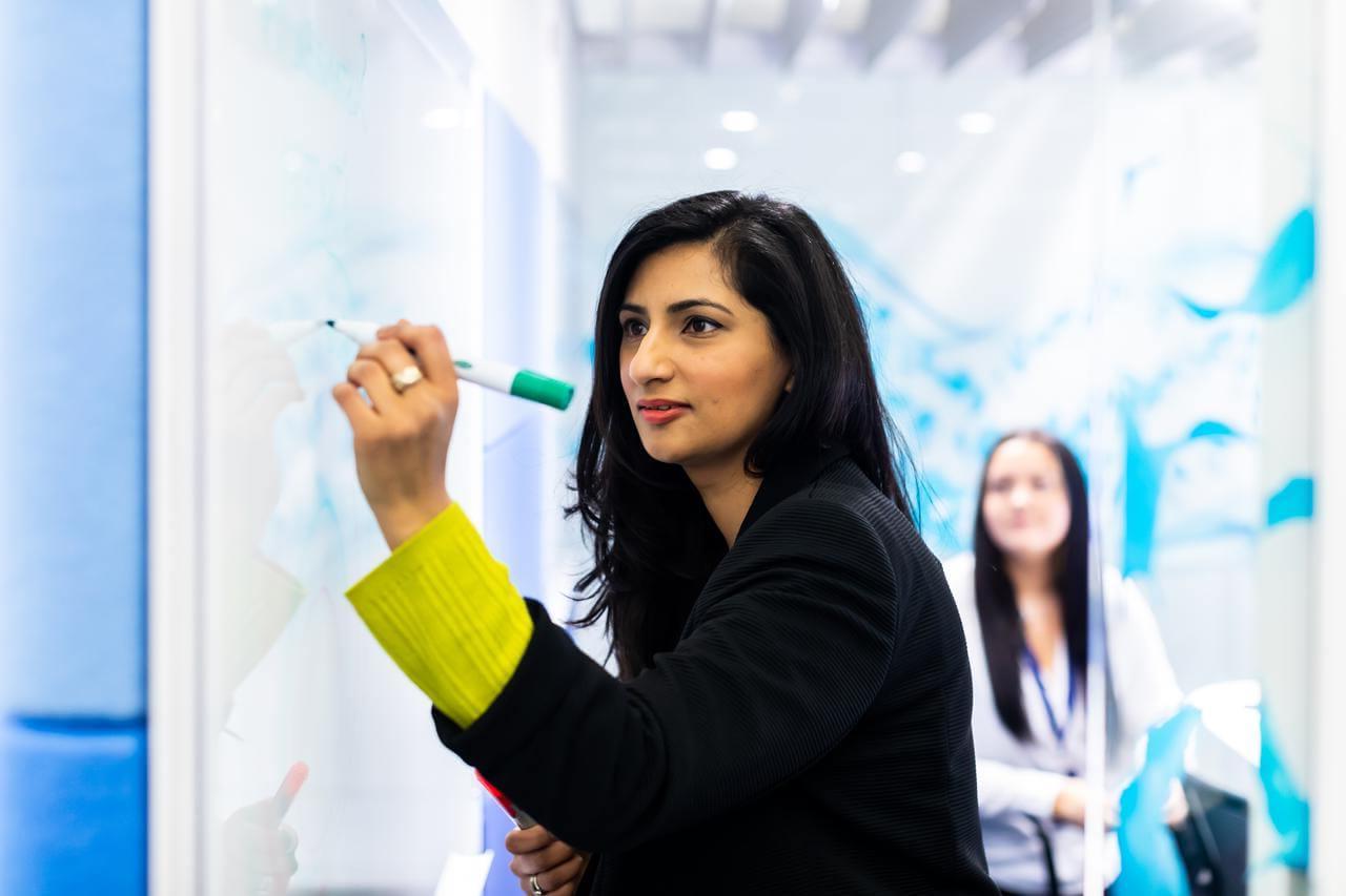 Women writing on an office whiteboard