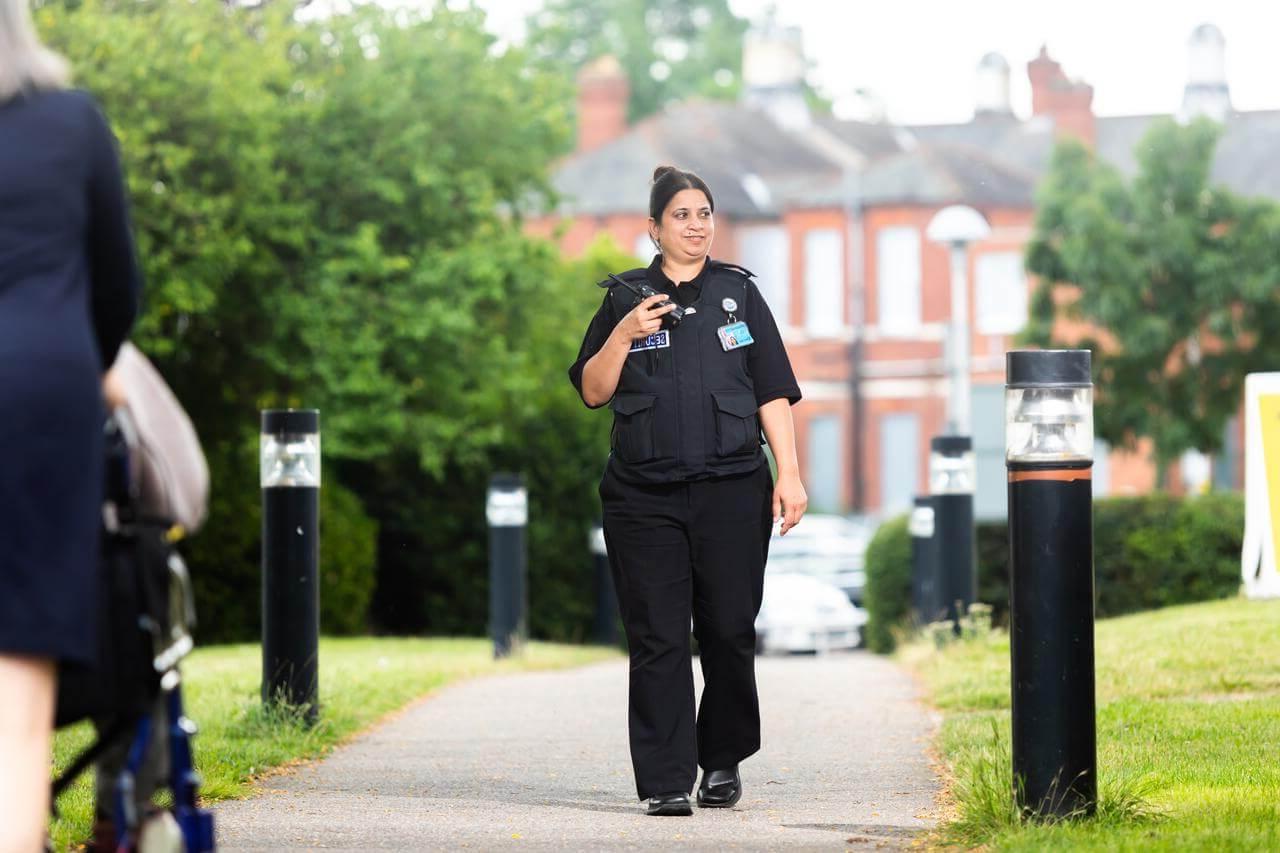 Female security guard walking through a park