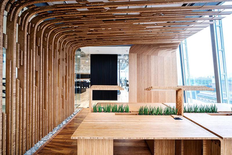 A meeting room at Mitie's offices in the Shard, London. The walls, desks and ceiling are all light patterned wood, with glass windows on the left